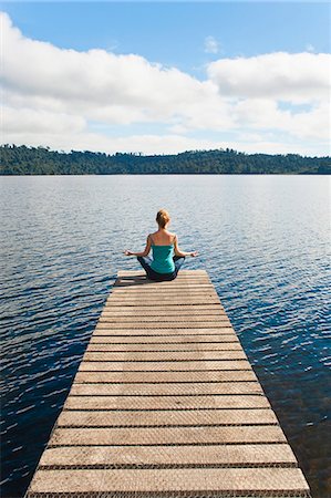 Woman meditating on a jetty, Lake Ianthe, West Coast, South Island, New Zealand, Pacific Stockbilder - Lizenzpflichtiges, Bildnummer: 841-07080619