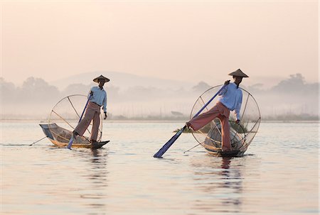 simsearch:841-06805749,k - Intha 'leg rowing' fishermen at dawn on Inle Lake who row traditional wooden boats using their leg and fish using nets stretched over conical bamboo frames, Inle Lake, Myanmar (Burma), Southeast Asia Stock Photo - Rights-Managed, Code: 841-07081664