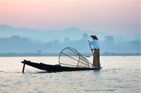 simsearch:841-06805745,k - Intha 'leg rowing' fishermen at dawn on Inle Lake who row traditional wooden boats using their leg and fish using nets stretched over conical bamboo frames, Inle Lake, Myanmar (Burma), Southeast Asia Fotografie stock - Rights-Managed, Codice: 841-07081661