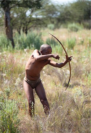 stereotype - San (Bushman) demonstrating traditional hunting technique with bow and arrow at the Okahandja Cultural Village, near Okahandja town, Namibia Stock Photo - Rights-Managed, Code: 841-07081783