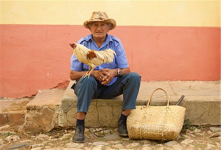 Local man wearing straw hat with cockerel standing on his knee, Trinidad, Cuba, West Indies, Central America Stock Photo - Rights-Managed, Code: 841-07081837