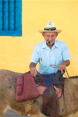 photo smoke man - Portrait of old man wearing straw hat and smoking cigar, posing against a yellow wall with his donkey for tourist pesos, Trinidad, Cuba, West Indies, Central America Stock Photo - Rights-Managed, Code: 841-07081838