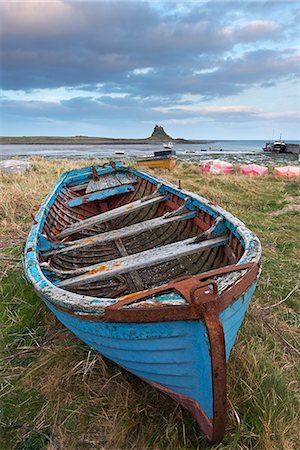 fishing boats uk - Old fishing boat pulled up on the shore at Holy Island, with the castle across the bay, Lindisfarne, Northumberland, England, United Kingdom, Europe Stock Photo - Rights-Managed, Code: 841-07205752
