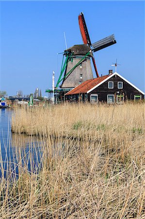 Preserved historic windmills and houses in Zaanse Schans, a village on the banks of the river Zaan, near Amsterdam, it is a popular tourist attraction and working museum, Zaandam, North Holland, Netherlands Stock Photo - Rights-Managed, Code: 841-07205869