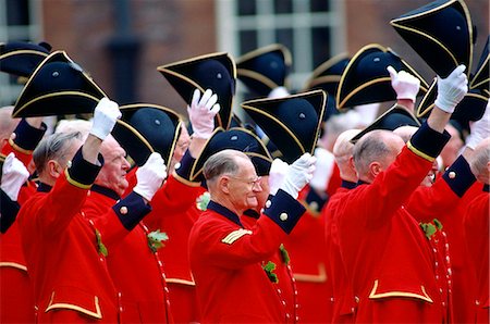 Chelsea Pensioners, dressed in their traditional uniform of bright red jacket, raising their tricorn hats and cheering during the Founder's Day Parade outside the Royal Hospital in Chelsea. Foto de stock - Con derechos protegidos, Código: 841-07201654
