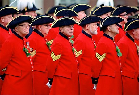 simsearch:841-07201683,k - Chelsea Pensioners, wearing their traditional uniform of red coat and black tricorn hat, standing outside the Royal Hospital in Chelsea during the Founder's Day Parade. Photographie de stock - Rights-Managed, Code: 841-07201653