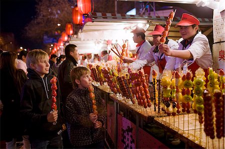 Boys eat candied strawberry sticks from stall in the Night Market, Wangfujing Street, Beijing, China Stock Photo - Rights-Managed, Code: 841-07457239