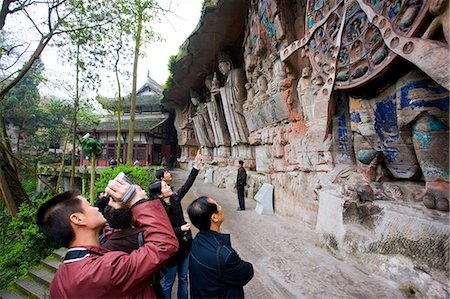 Tourist photographs Anicca, God of Destiny holds wheel of life, Dazu rock carvings, Mount Baoding, China Stock Photo - Rights-Managed, Code: 841-07457274