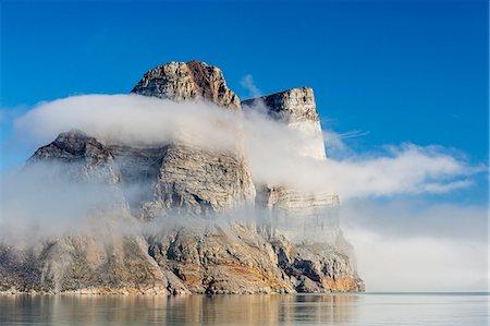 Fog lifting on the steep cliffs of Icy Arm, Baffin Island, Nunavut, Canada, North America Foto de stock - Direito Controlado, Número: 841-07589821