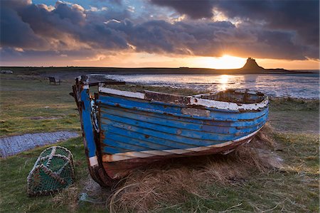 Decaying fishing boat on Holy Island at dawn, with Lindisfarne Castle beyond, Northumberland, England, United Kingdom, Europe Foto de stock - Direito Controlado, Número: 841-07782543