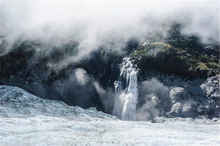 south island new zealand glaciers - Aerial of a waterfall flowing into the icefield of Fox Glacier, Westland Tai Poutini National Park, South Island, New Zealand, Pacific Stock Photo - Rights-Managed, Code: 841-07782673