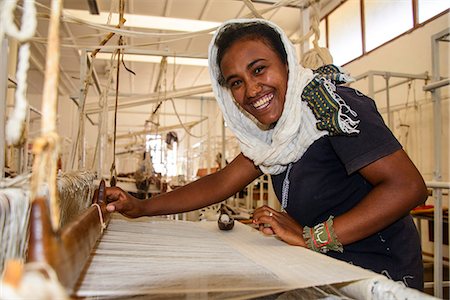 Friendly woman working on a hand weaving loom on a social project in the highlands of Eritrea, Africa Foto de stock - Direito Controlado, Número: 841-07782925