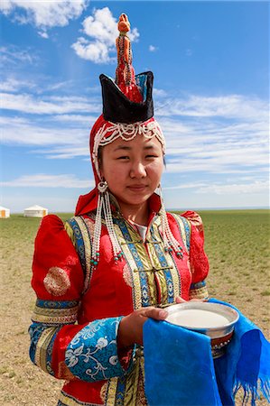 Woman in red deel and pointed hat with silver bowl of milk to welcome visitors, Gobi desert, near Bulgan, Omnogov, Mongolia, Central Asia, Asia Photographie de stock - Rights-Managed, Code: 841-08239965