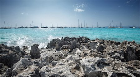 Jagged rocks with sailboats idling in the azure waters of Formentera, Balearic Islands, Spain, Mediterranean, Europe Photographie de stock - Rights-Managed, Code: 841-08279061