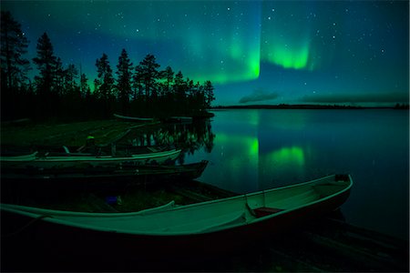 Beached canoes and Aurora Borealis and stars reflected in lake at night, Muonio, Lapland, Finland, Scandinavia, Europe Stock Photo - Rights-Managed, Code: 841-08279162