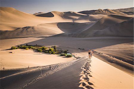 Tourists climbing sand dunes at sunset at Huacachina, a village in the desert, Ica Region, Peru, South America Stock Photo - Rights-Managed, Code: 841-08421097