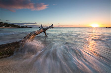 Waves on a tree trunk on the beach framed by the Caribbean sunset, Hawksbill Bay, Antigua, Antigua and Barbuda, Leeward Islands, West Indies, Caribbean, Central America Stock Photo - Rights-Managed, Code: 841-08717974