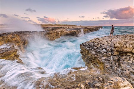 rocky coast - Hiker on the cliffs admires the crashing waves at Devil's Bridge, Antigua, Antigua and Barbuda, Leeward Islands, West Indies, Caribbean, Central America Stock Photo - Rights-Managed, Code: 841-08717975