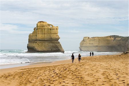 simsearch:841-05961821,k - People walk along a beach with one of the Twelve Apostles geological formation in the background, Victoria, Australia, Pacific Photographie de stock - Rights-Managed, Code: 841-08781801