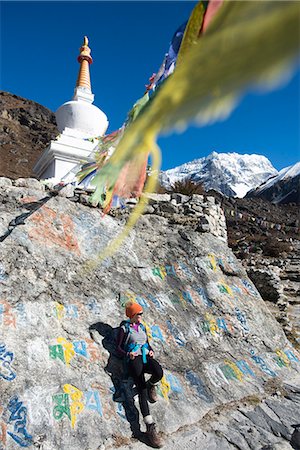 A woman trekking in the Langtang valley stops near a colorful Mani Stone wall below a Stupa decorated with Buddhist prayer flags, Langtang Region, Himalayas, Nepal, Asia Stock Photo - Rights-Managed, Code: 841-08797804