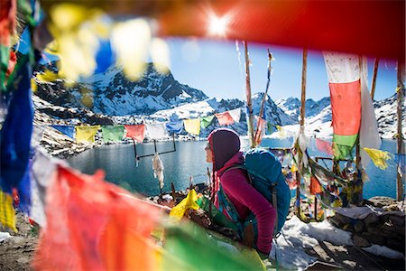 A trekker stands among prayer flags beside the holy lakes at Gosainkund in the Langtang region, Himalayas, Nepal, Asia Stock Photo - Rights-Managed, Code: 841-08797808