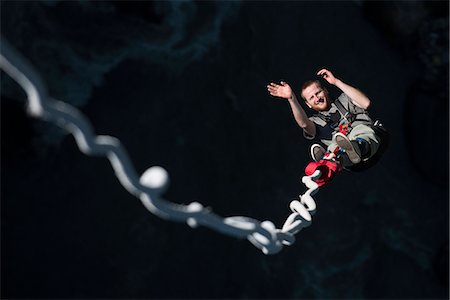 extreme sports and connect - A man smiles for the camera as he is bounced back up during a Bungee jump at The Last Resort, Nepal, Asia Stock Photo - Rights-Managed, Code: 841-08797828