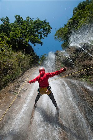 A man pauses to hold his arms in the falling water while canyoning, Nepal, Asia Stock Photo - Rights-Managed, Code: 841-08797874