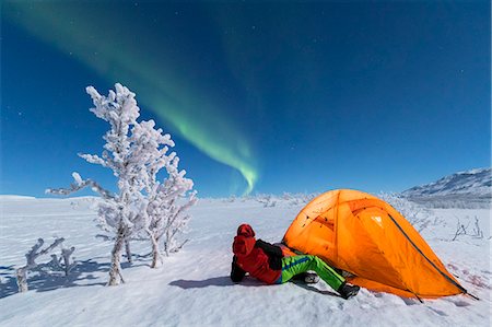Hiker outside a tent looks at the Northern Lights (Aurora Borealis), Abisko, Kiruna Municipality, Norrbotten County, Lapland, Sweden, Scandinavia, Europe Stock Photo - Rights-Managed, Code: 841-09076772