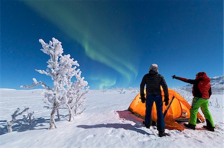 Hikers outside tent look at the Northern Lights (Aurora Borealis), Abisko, Kiruna Municipality, Norrbotten County, Lapland, Sweden, Scandinavia, Europe Foto de stock - Con derechos protegidos, Código: 841-09076773