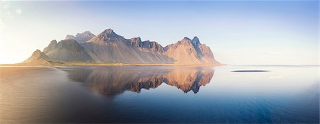 Panoramic view of Vestrahorn Mountain range reflecting in shallows of black volcanic beach, Stokksnes, South Iceland, Polar Regions Stock Photo - Rights-Managed, Code: 841-09076989