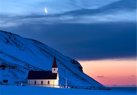 Floodlit church at dawn against snow covered mountains, winter, near Vik, South Iceland, Polar Regions Foto de stock - Con derechos protegidos, Código: 841-09077004
