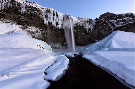 simsearch:400-07298205,k - Winter view of Seljalandsfoss Waterfall at dusk with snow covered foreground and icicles hanging from cliffs, South Iceland, Polar Regions Foto de stock - Con derechos protegidos, Código: 841-09077011