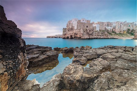 pozza di marea - Turquoise sea at sunrise framed by the old town perched on the rocks, Polignano a Mare, Province of Bari, Apulia, Italy, Europe Fotografie stock - Rights-Managed, Codice: 841-09085863