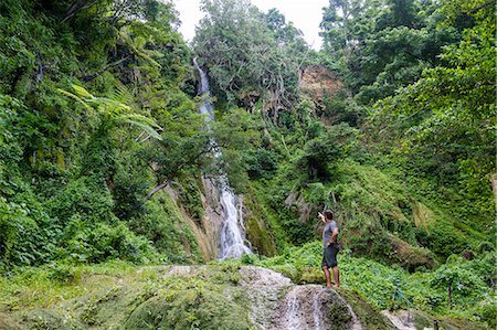 Man standing underneath the Mele Cascades, Efate, Vanuatu, Pacific Fotografie stock - Rights-Managed, Codice: 841-09085907