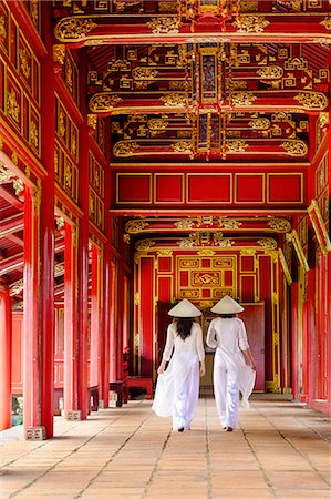 simsearch:6119-09074476,k - Two women in traditional Ao Dai dress and Non La conical hats in the Forbidden Purple City of Hue, UNESCO World Heritage Site, Thua Thien Hue, Vietnam, Indochina, Southeast Asia, Asia Foto de stock - Direito Controlado, Número: 841-09108104