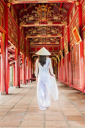 A woman in a traditional Ao Dai dress and Non La conical hat in the Forbidden Purple City of Hue, UNESCO World Heritage Site, Thua Thien Hue, Vietnam, Indochina, Southeast Asia, Asia Stock Photo - Rights-Managed, Code: 841-09108107