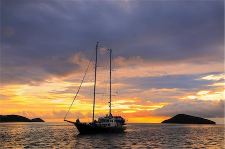 Silhouetted tourist sailboat at sunrise anchored near Chinese Hat island in Galapagos National Park, Ecuador, South America Foto de stock - Con derechos protegidos, Código: 841-09147479