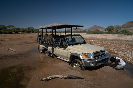 Guide tries to jack up safari vehicle stuck in the sand of Hoarusib Riverbed, Puros, north of Sesfontein, Nambia, Africa Photographie de stock - Rights-Managed, Code: 841-09183726