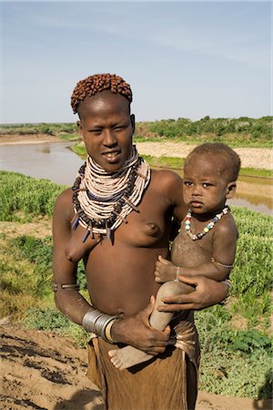 Mother and baby of the Hamer tribe, the woman's hair is treated with ochre, water and resin then twisted into tresses called goscha, Lower Omo Valley, Ethiopia, Africa Foto de stock - Con derechos protegidos, Código: 841-02705912