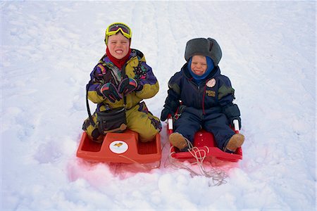 Two children on red toboggans playing in the snow in Finland, Scandinavia, Europe Stock Photo - Rights-Managed, Code: 841-02705999