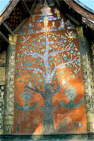 Glass mosaic of tree of life on wall of the 16th century Sim, Wat Xiang Thong, Luang Prabang, UNESCO World Heritage Site, Laos, Indochina, Southeast Asia Foto de stock - Con derechos protegidos, Código: 841-02703858