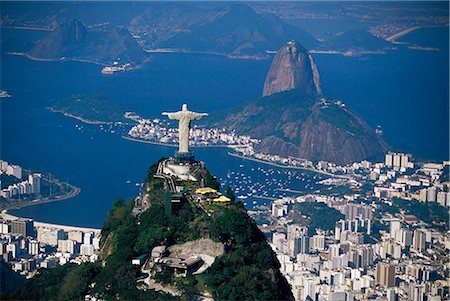 Aerial view of city with the Cristo Redentor (Christ the Redeemer) statue in foreground and Pao de Acucar (Sugar Loaf) in the background, Rio de Janeiro, Brazil, South America Foto de stock - Con derechos protegidos, Código: 841-02715042