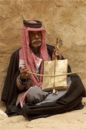 Bedouin man in traditional dress playing a musical instrument, Beida (Little Petra), Jordan, Middle East Stock Photo - Rights-Managed, Code: 841-02717249