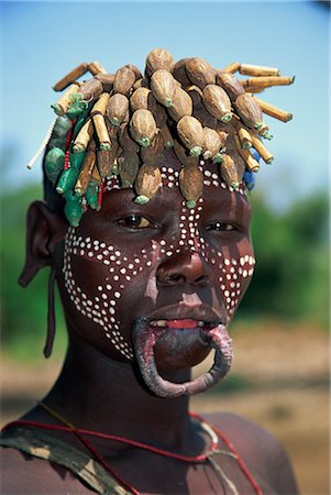 A member of the Mursi Tribe with lip plates, head dress and body paint in Mago National Park, Ethiopia, Africa Foto de stock - Con derechos protegidos, Código: 841-02711693