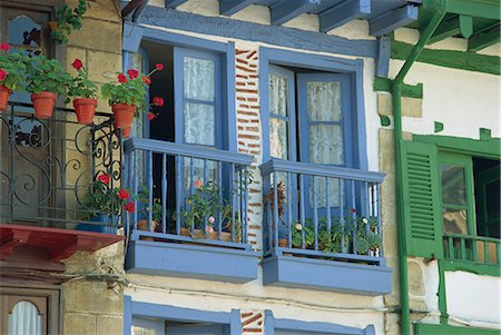 Close-up of balconies and windows painted blue and green, with potted plants including geraniums, on a village house at Hondaribbia, Pais Vasco (Basque area), Spain, Europe Stock Photo - Rights-Managed, Code: 841-02713508