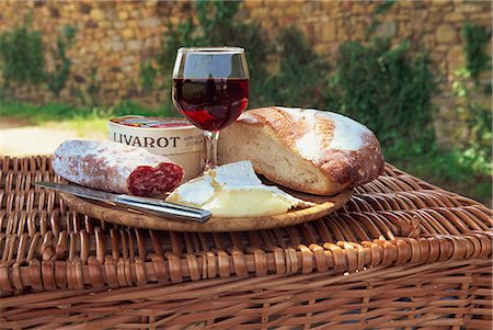 french food and wine - Still life of bread, cheese, glass of red wine and sausage, picnic lunch on top of a wicker basket, in the Dordogne, France, Europe Stock Photo - Rights-Managed, Code: 841-02713520