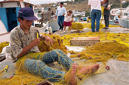 Fisherman repairing his net hi-res stock photography and images