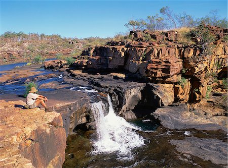 Un homme assis sur un rocher en amont de la rivière, à la première étape des chutes Mitchell dans le Kimberley, Australie-occidentale, Australie, Pacifique Photographie de stock - Rights-Managed, Code: 841-02832464