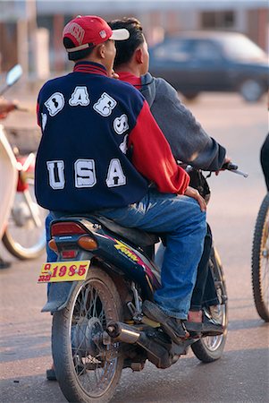 simsearch:841-02831527,k - Young boy in western clothes, denims and baseball cap on the back of a motorcycle in Vientiane, Laos, Indochina, Southeast Asia, Asia Stock Photo - Rights-Managed, Code: 841-02899075
