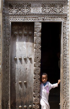 simsearch:841-03031111,k - Young boy looking out from a traditional carved wooden Arab door in Stone Town, Zanzibar, Tanzania, East Africa Foto de stock - Con derechos protegidos, Código: 841-02899908